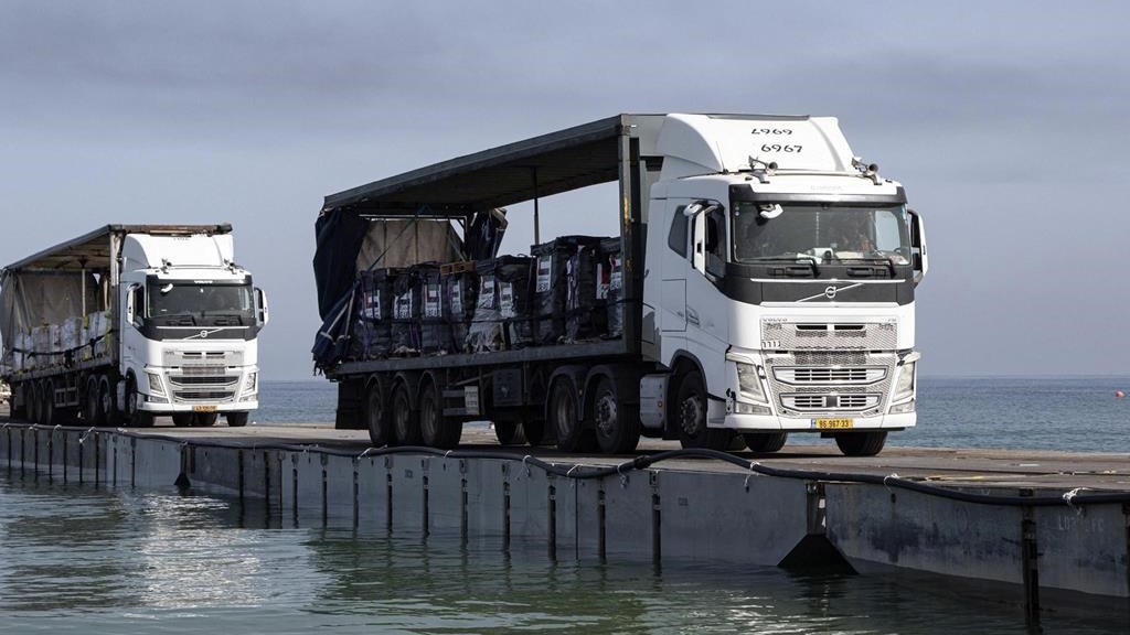 Cette image montre des camions chargés d'aide humanitaire des Émirats arabes unis et de l'Agence des États-Unis pour le développement international traversant la jetée du Trident avant d'arriver sur la plage de la bande de Gaza, le 17 mai 2024.