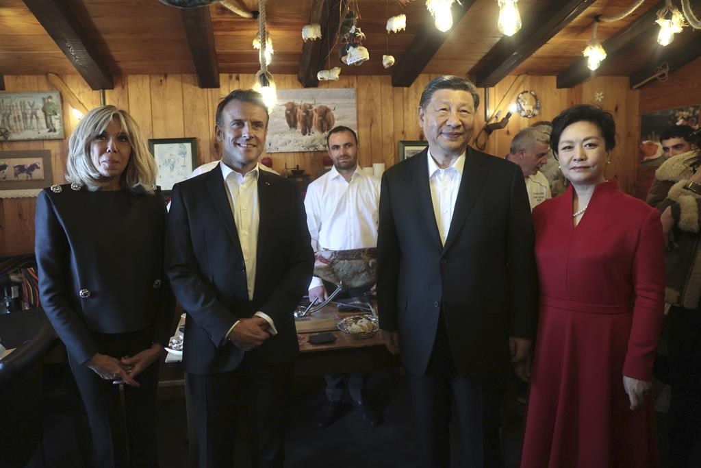 Le président chinois Xi Jinping et son épouse Peng Liyuan, à droite, le président français Emmanuel Macron et son épouse Brigitte Macron, à gauche, posent dans un restaurant, le mardi 7 mai 2024 au col du Tourmalet, dans les Pyrénées.