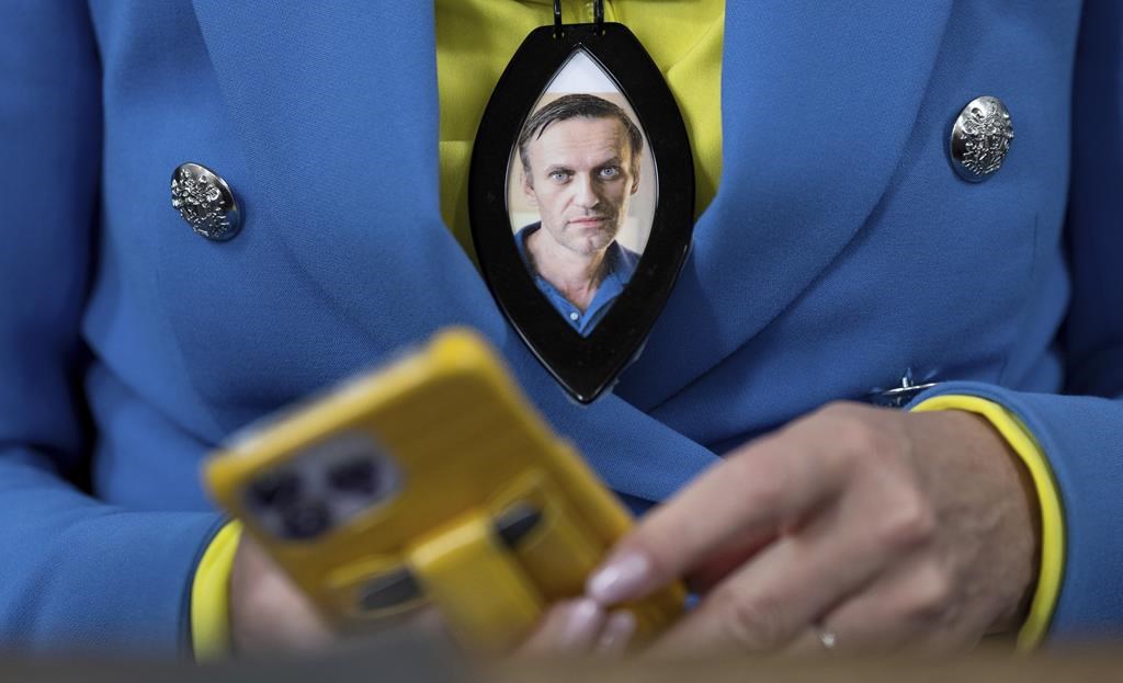 <p>Canada is sanctioning 13 more Russians from the country's intelligence service, police force and its corrections system for their role in the poisoning, imprisonment and death of Russian opposition leader Alexei Navalny. A woman wears a photograph of deceased Russian opposition leader Alexei Navalny during a service in St. Mary's Church on the occasion of his birthday, in Berlin, Tuesday, June 4, 2024. THE CANADIAN PRESS/AP-dpa, Christoph Gollnow</p>