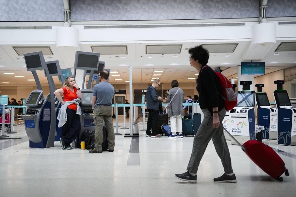 Des passagers sont vus dans la zone d'enregistrement de WestJet à l'aéroport international Pearson, à Toronto, le samedi 29 juin 2024. LA PRESSE CANADIENNE/Christopher Katsarov