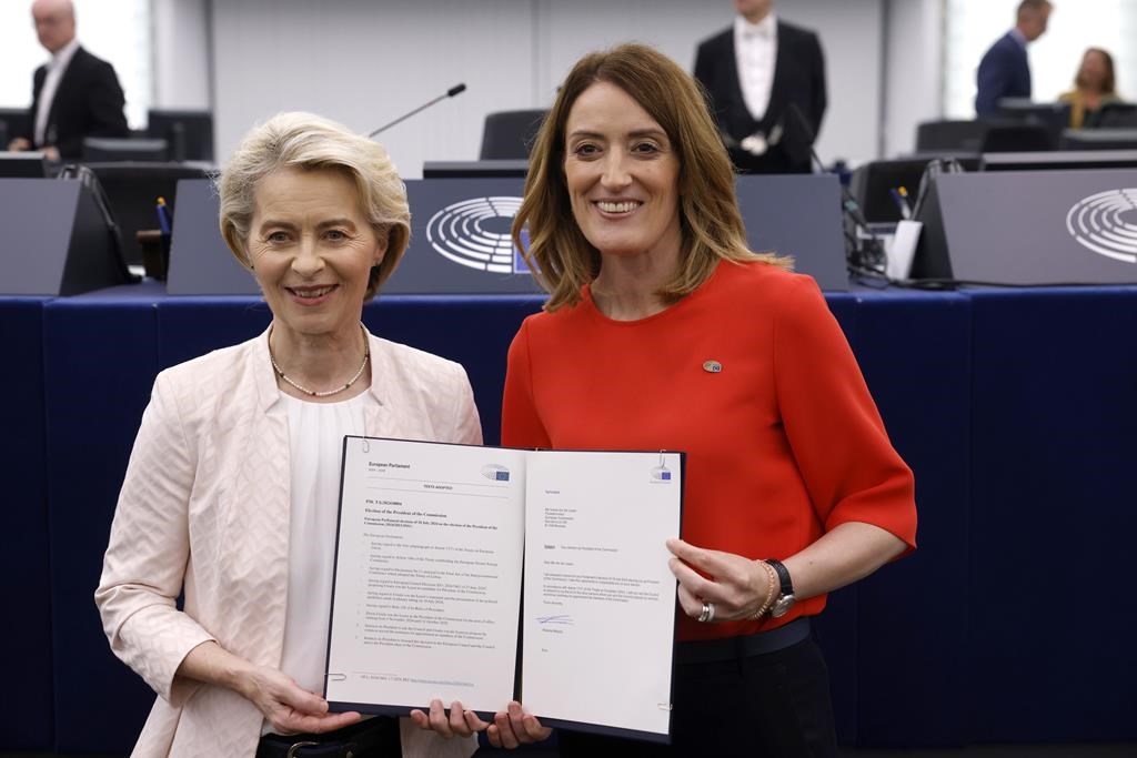 European Commission President Ursula von der Leyen, left, and European Parliament President Roberta Metsola, right, pose with the offical text declaration of the election of the European Commission president at the European Parliament in Strasbourg, eastern France, Thursday, July 18, 2024. Lawmakers at the European Parliament have re-elected Ursula von der Leyen to a second 5-year term as president of the European Union's executive commission. The re-election ensures leadership continuity for the 27-nation bloc as it wrestles with crises ranging from the war in Ukraine to climate change, migration and housing shortages. (AP Photo/Jean-Francois Badias)