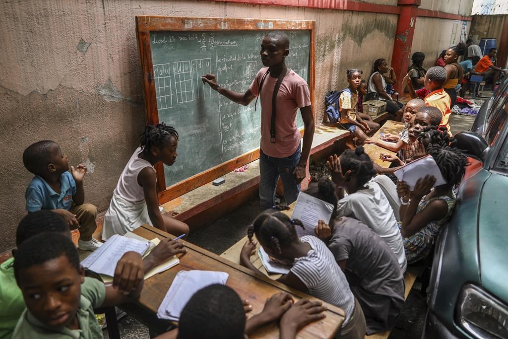 FILE - An instructor teaches math to children living in a shelter for families who fled their homes amid gang violence, in Port-au-Prince, Haiti, May 27, 2024. (AP Photo/Odelyn Joseph, File)