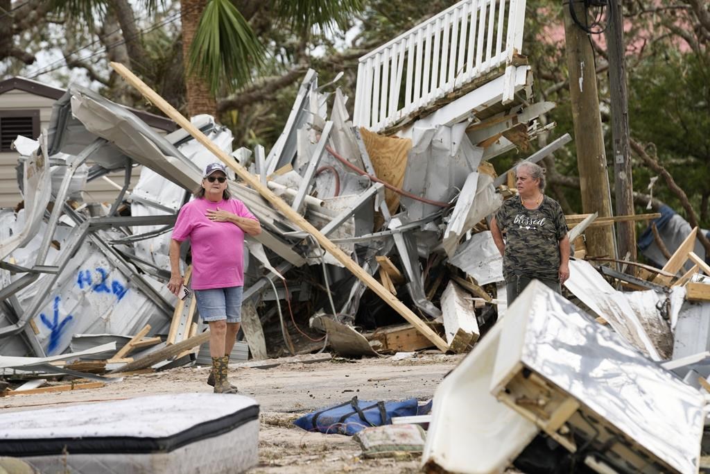 Frankie Johnson, left, talks with fellow resident Charlene Huggins, whose home was destroyed, amid the destruction in the aftermath of Hurricane Helene, in Horseshoe Beach, Fla., Saturday, Sept. 28, 2024. (AP Photo/Gerald Herbert)