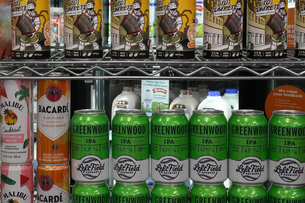 Beer cans are stacked in front a display of milk at a convenience store in Toronto, Thursday, Dec. 14, 2023. THE CANADIAN PRESS/Chris Young