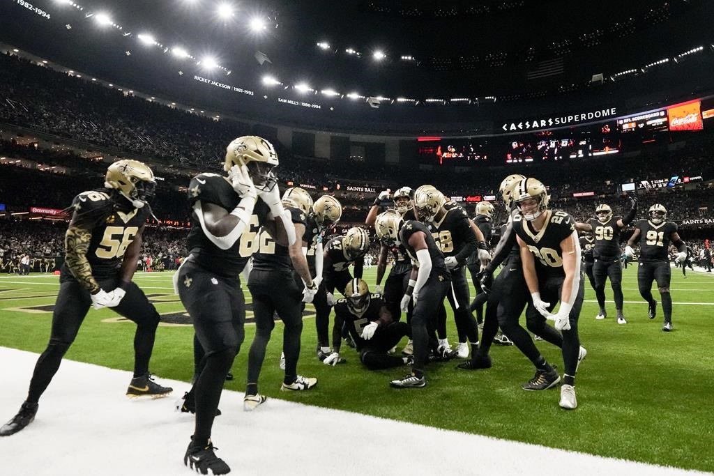 Les membres de la défense des Saints de la Nouvelle-Orléans célèbrent une interception contre les Carolina Panthers pendant la première mi-temps d'un match de football de la NFL, dimanche 8 septembre 2024, à la Nouvelle-Orléans. 