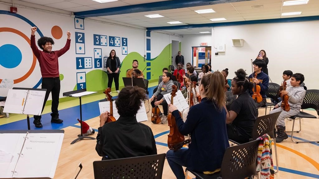 Le directeur musical de l’Orchestre symphonique de Montréal, Rafael Payare, devant des enfants qui jouent de la musique, à Montréal, en décembre 2024. PC-Photo fournie par Antoine Saito **CRÉDIT OBLIGATOIRE** 